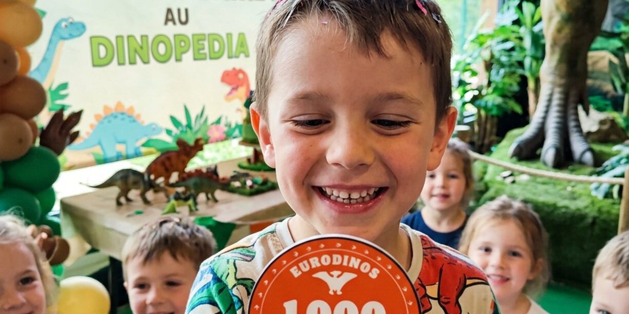Enfant qui fête son anniversaire à Dinopedia avec une pièce de 1000 EuroDinos