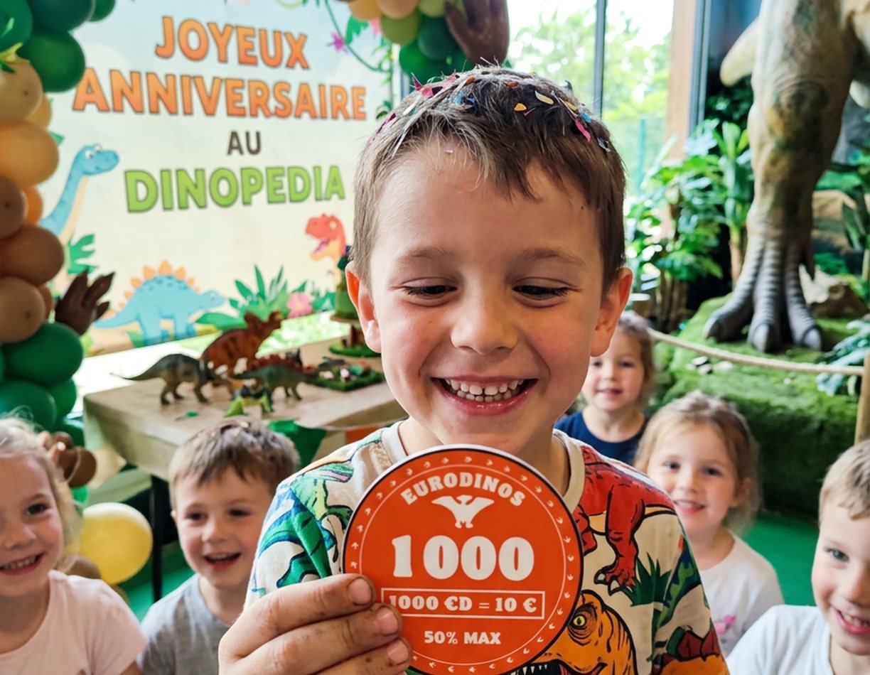 Enfant qui fête son anniversaire à Dinopedia avec une pièce de 1000 EuroDinos